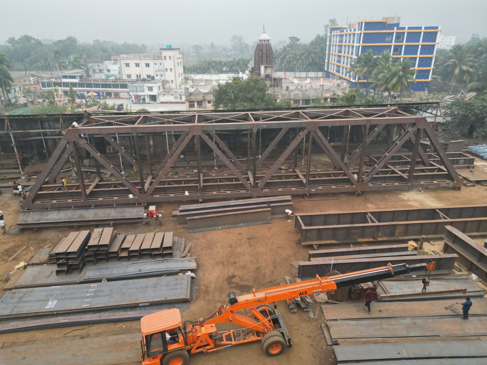 Large steel truss assembly with lifting equipment in the yard