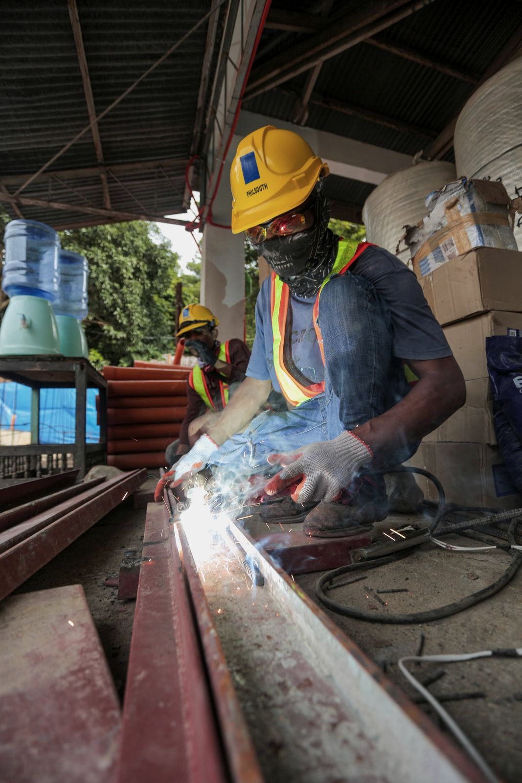 Welder joining steel sections in a shower of sparks